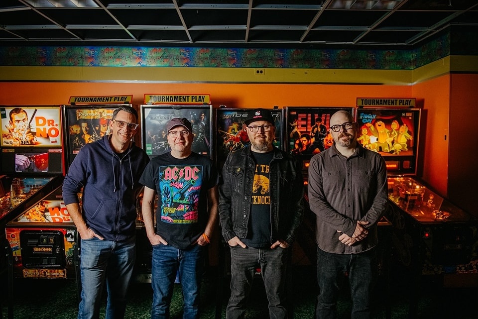 Smoking Popes band standing in front of pinball machines.